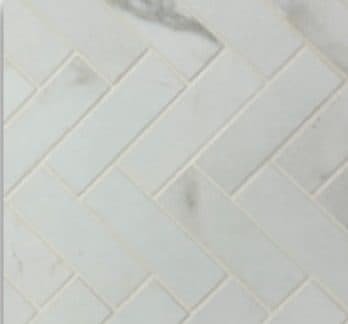 Bathroom tile detail in a pale herringbone pattern.