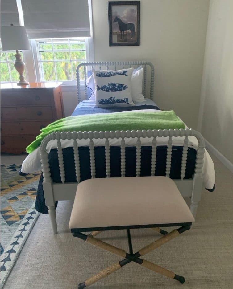 Farmhouse bedroom with striped bedding, green accents, and upholstered bench.