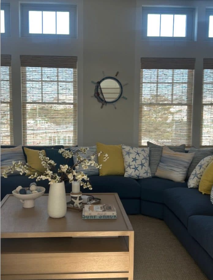 Long Beach Island living room with blue sectional seating, woven textures, and tall windows.