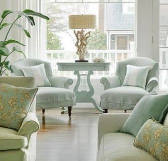 Newtown sitting room with pale green chairs and a small round table.