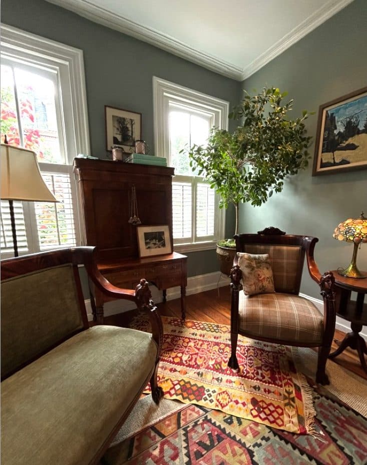 Philadelphia brownstone sitting room with layered chairs, framed artwork, and a patterned rug.