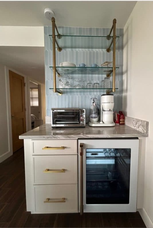 St. Augustine kitchen bar with brass faucet, glass shelving, and compact storage.