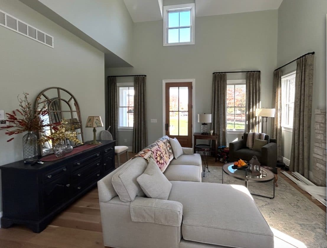 Yardley living room with high ceilings, neutral seating, and dark wood storage.